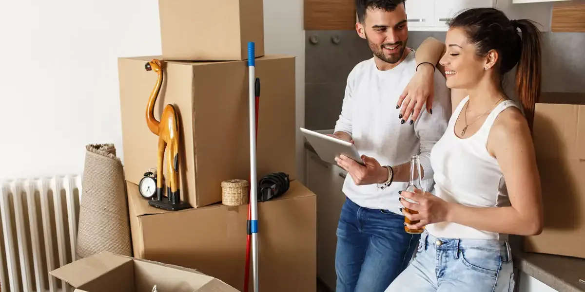 comment-faire-pour-un-demenagement-2 Couple au milieu des cartons de déménagement avec une tablette en main