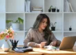 Femme travaillant depuis chez elle sur son ordinateur