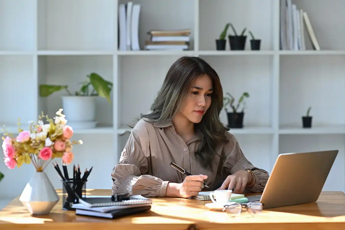 Femme travaillant depuis chez elle sur son ordinateur
