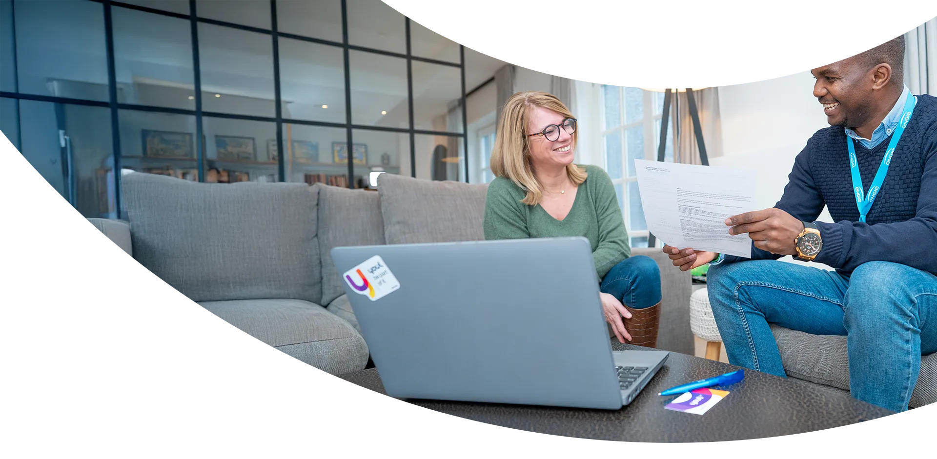 Cliente et conseiller Youl assis dans un fauteuil gris devant un ordinateur