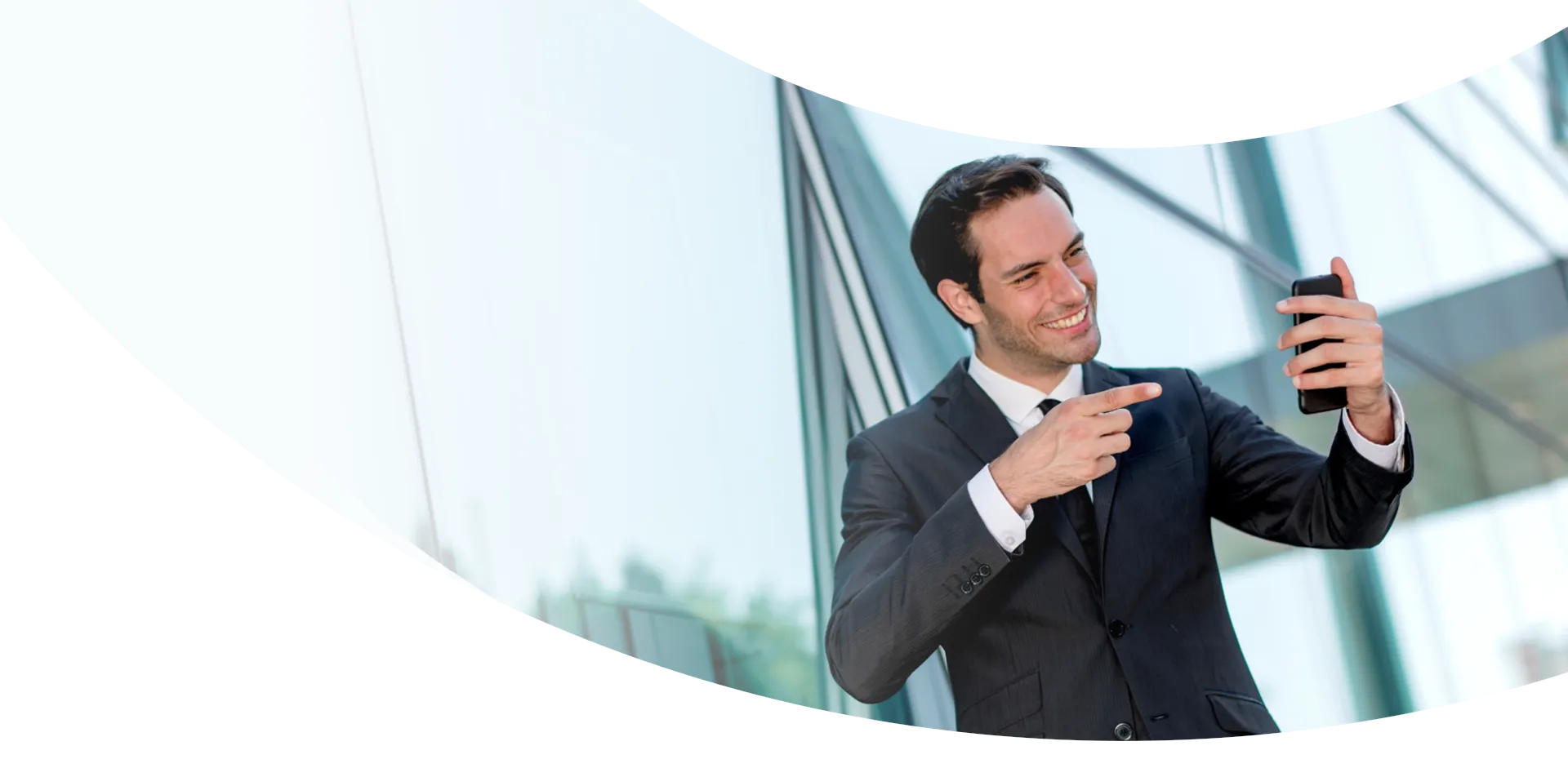 Employé Youl en costard et souriant montrant le téléphone dans sa main